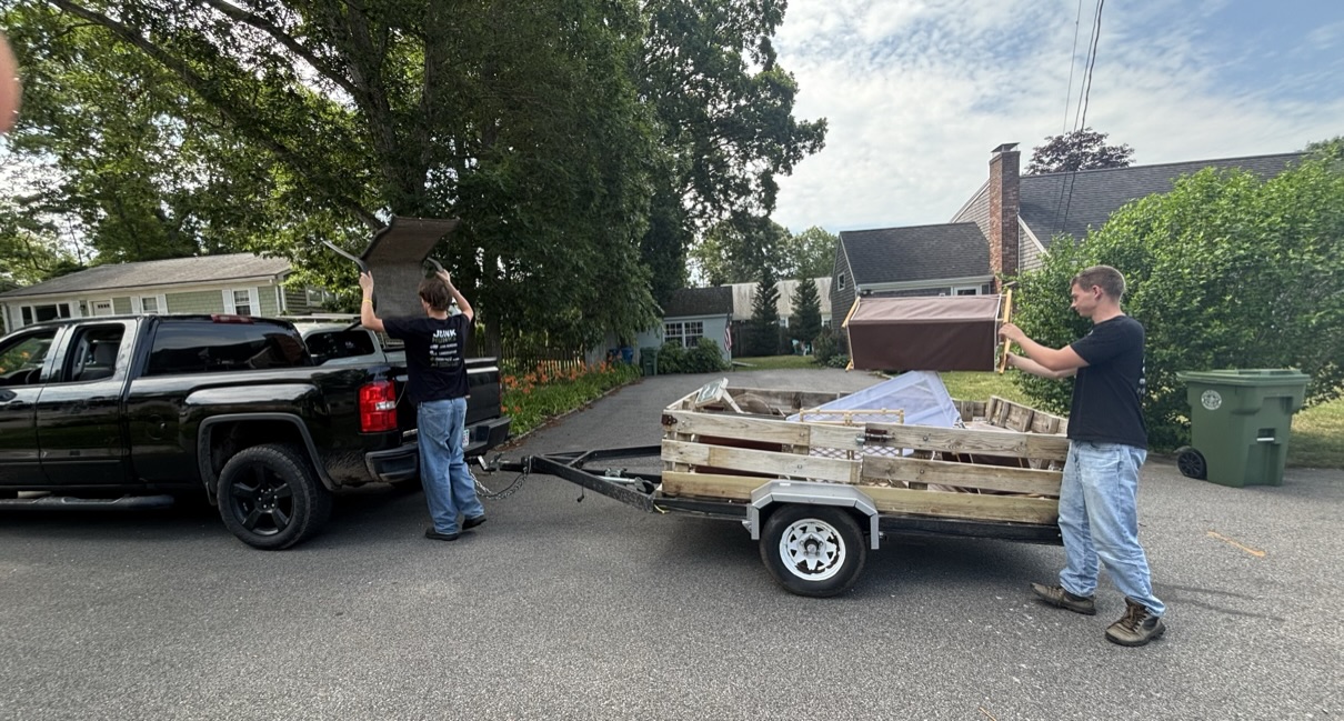 The Junk Hunks crew loading a trailer with junk