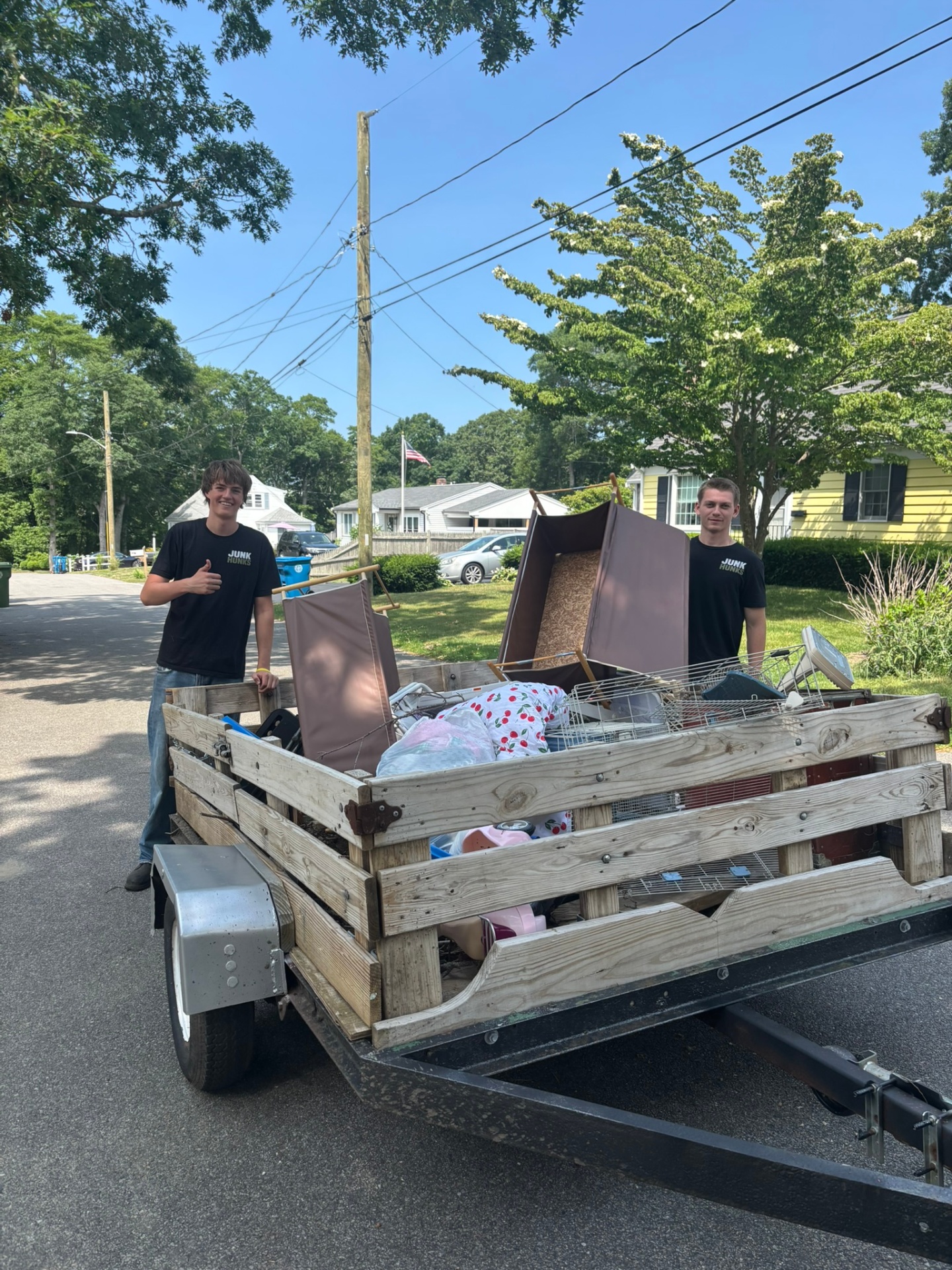 The Junk Hunks crew with a trailer full of furniture and household junk